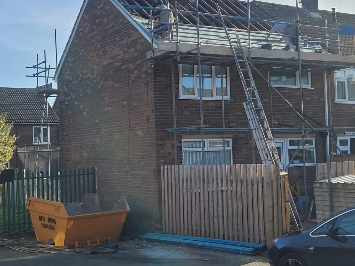Roof stripped back on a scaffolded brick house