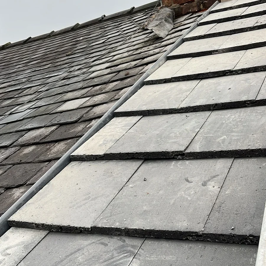 Slate roof junction beside a brick chimney