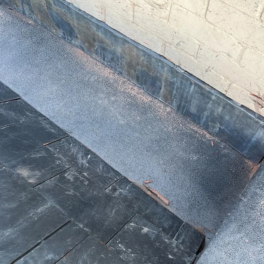 Flashing detail along a roof and rendered wall junction