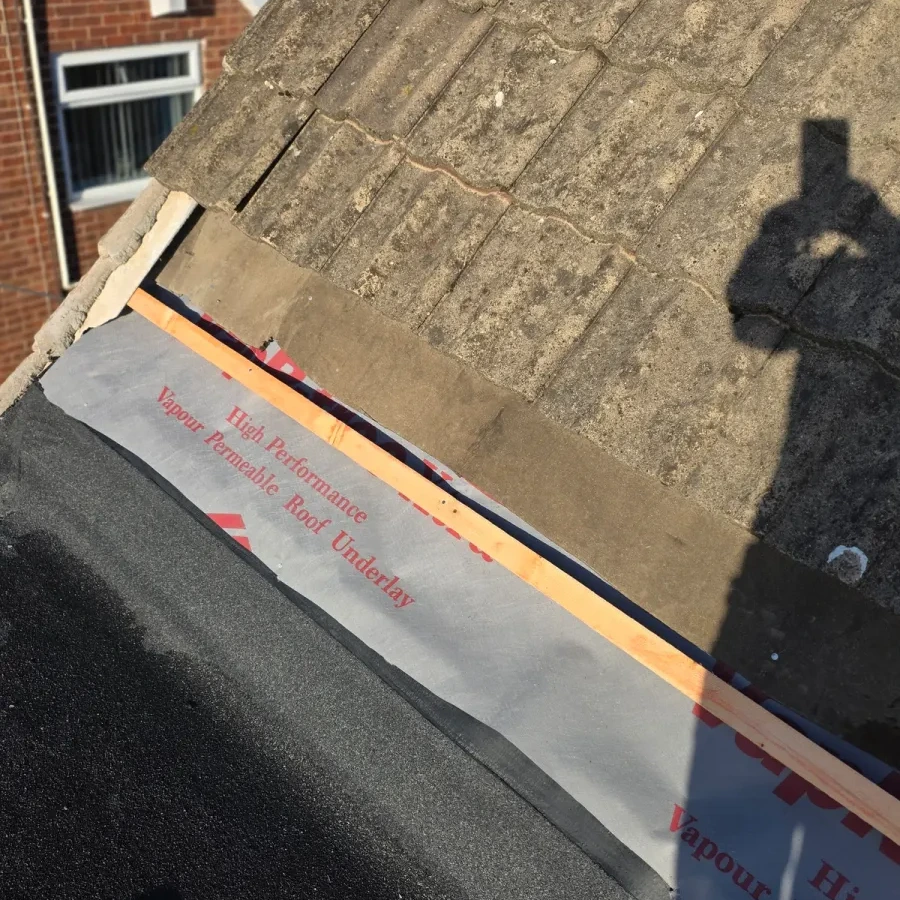 Roof edge underlay exposed beside the adjoining flat surface