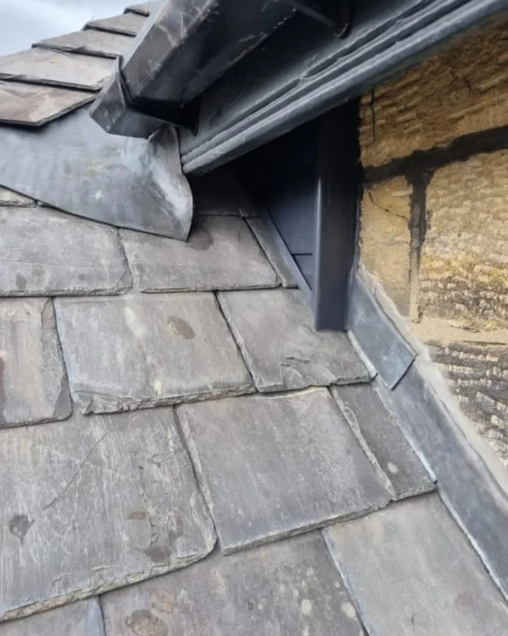 Close view of slate tiles and flashing beside a dormer