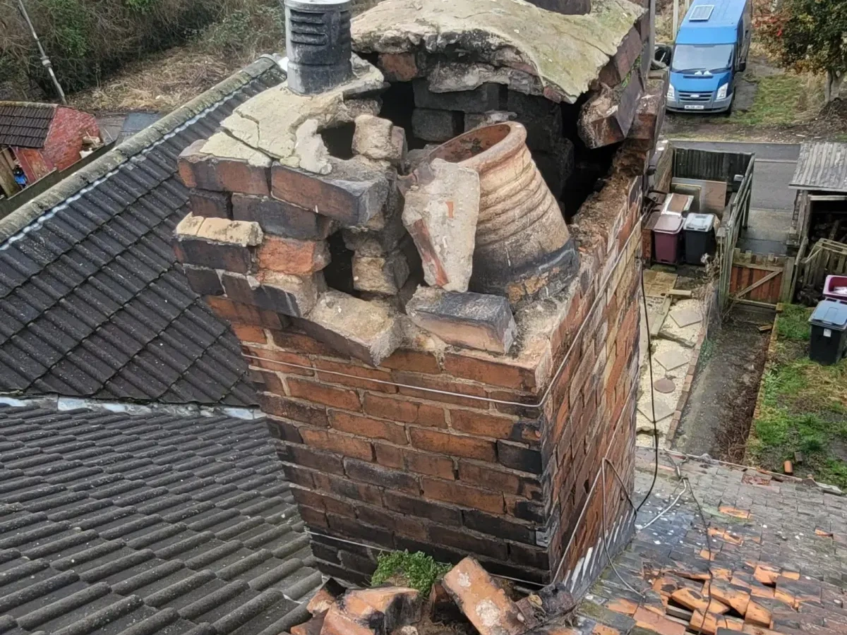 Brick chimney stack with loose and exposed masonry
