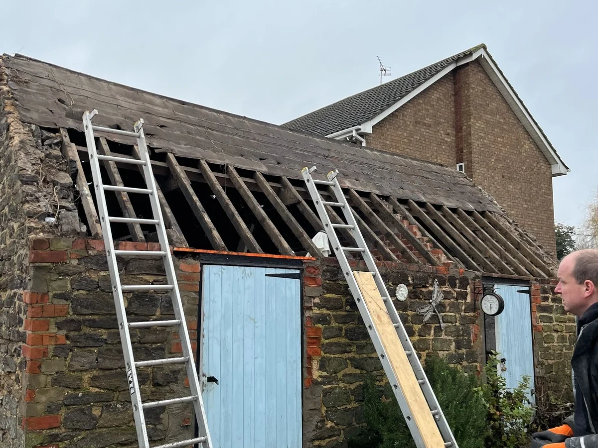Outbuilding roof stripped back to its timber rafters
