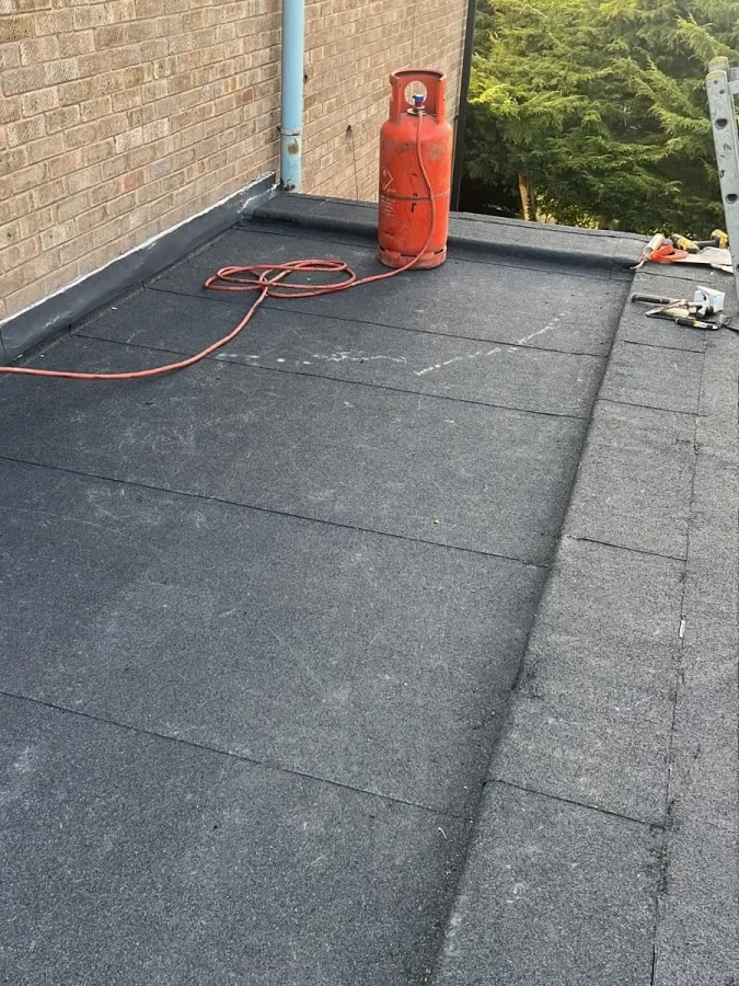 Flat roofing work beside an external wall