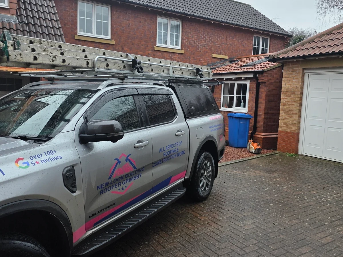 New Look work vehicle beside a brick house and paved drive