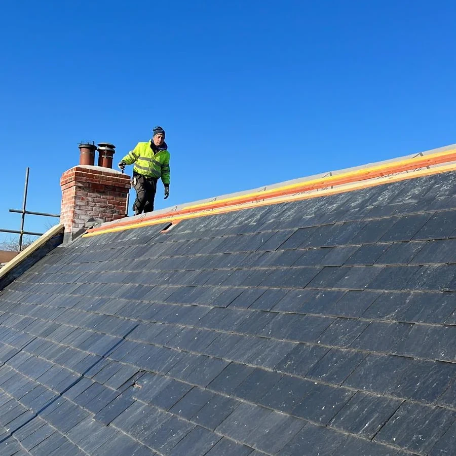 Roofing work near the ridge and chimney