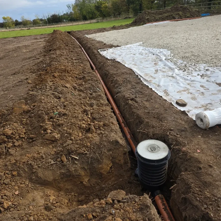 Ground preparation with drainage pipe and brick edging