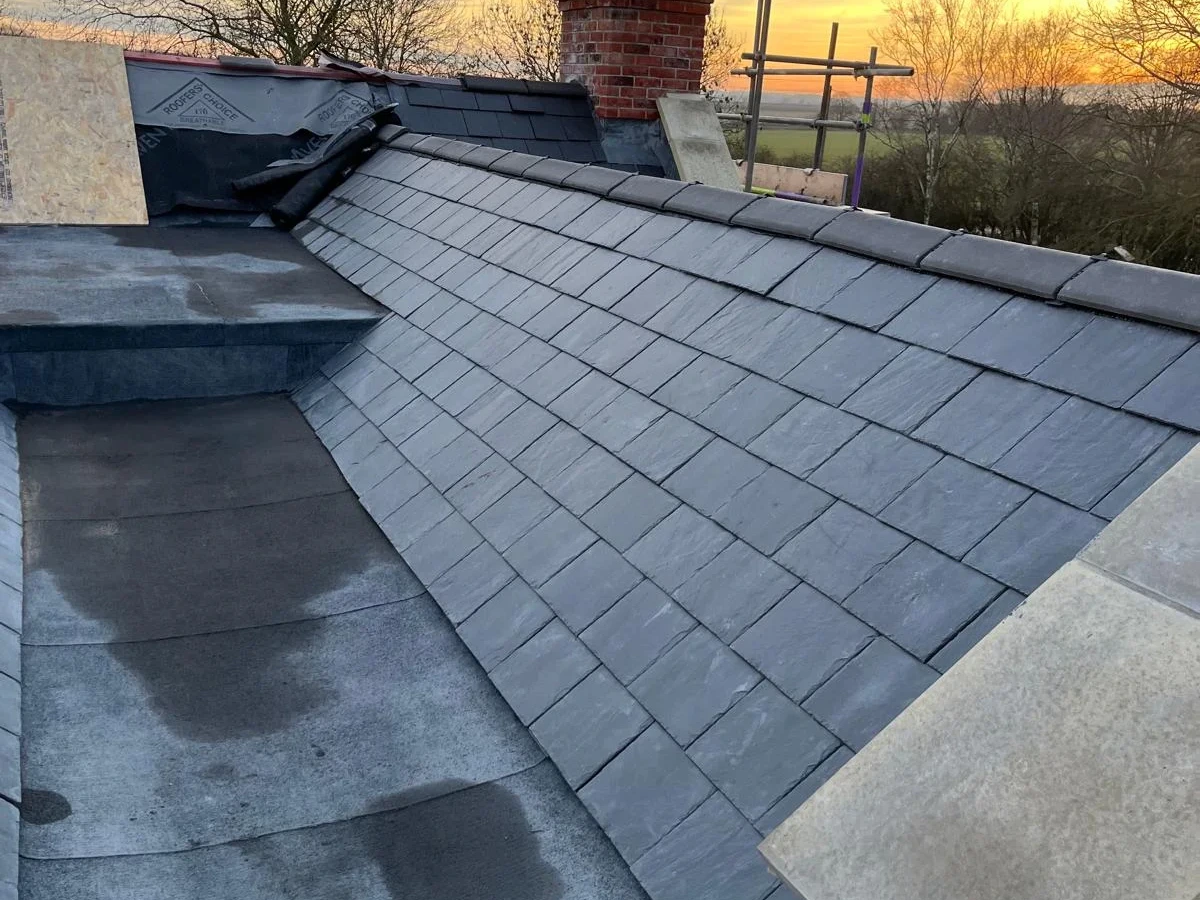 Slate roof slopes and central valley at sunset