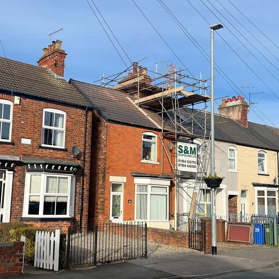 Street view of a scaffolded roof work site