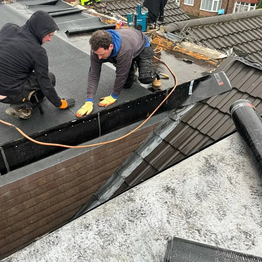 Team fitting a flat roof covering at the roof edge