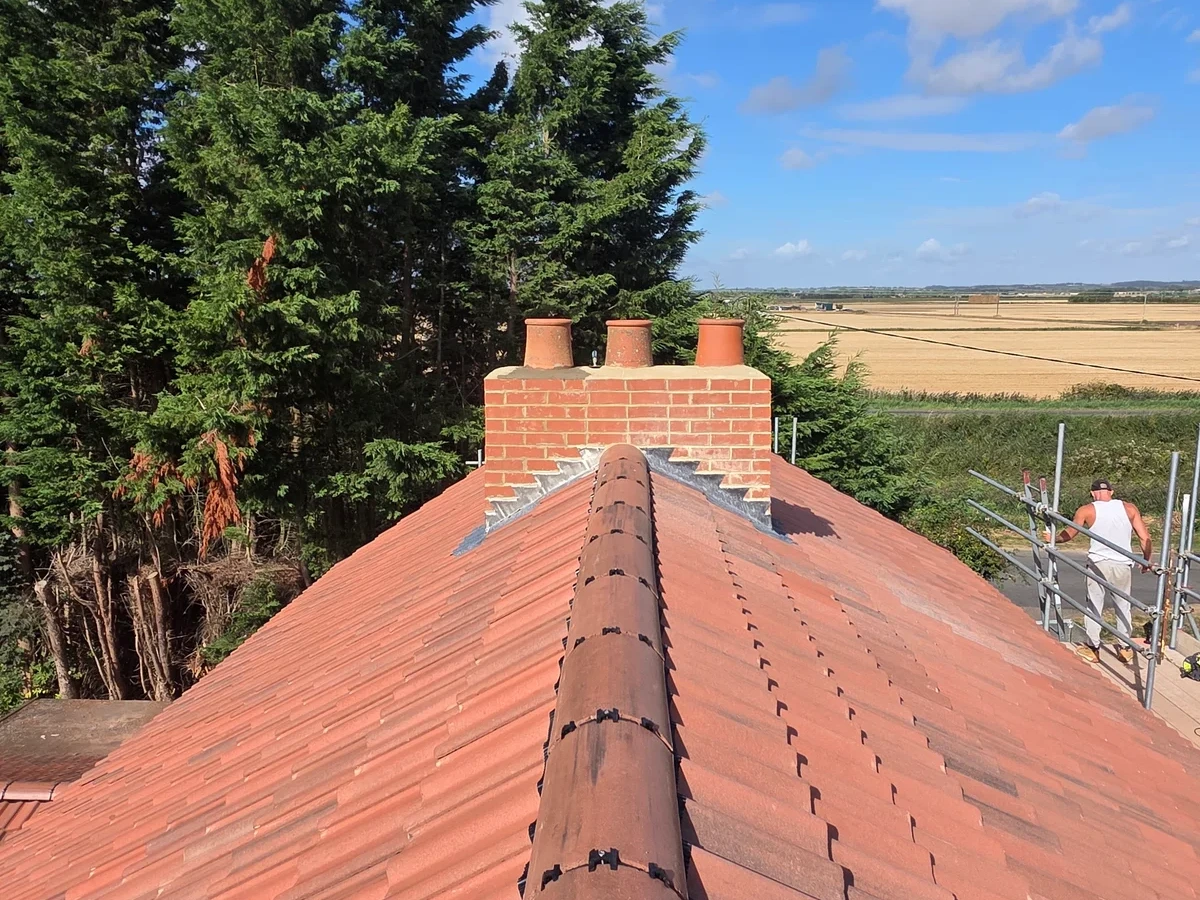 Red tiled roof ridge leading to a chimney stack