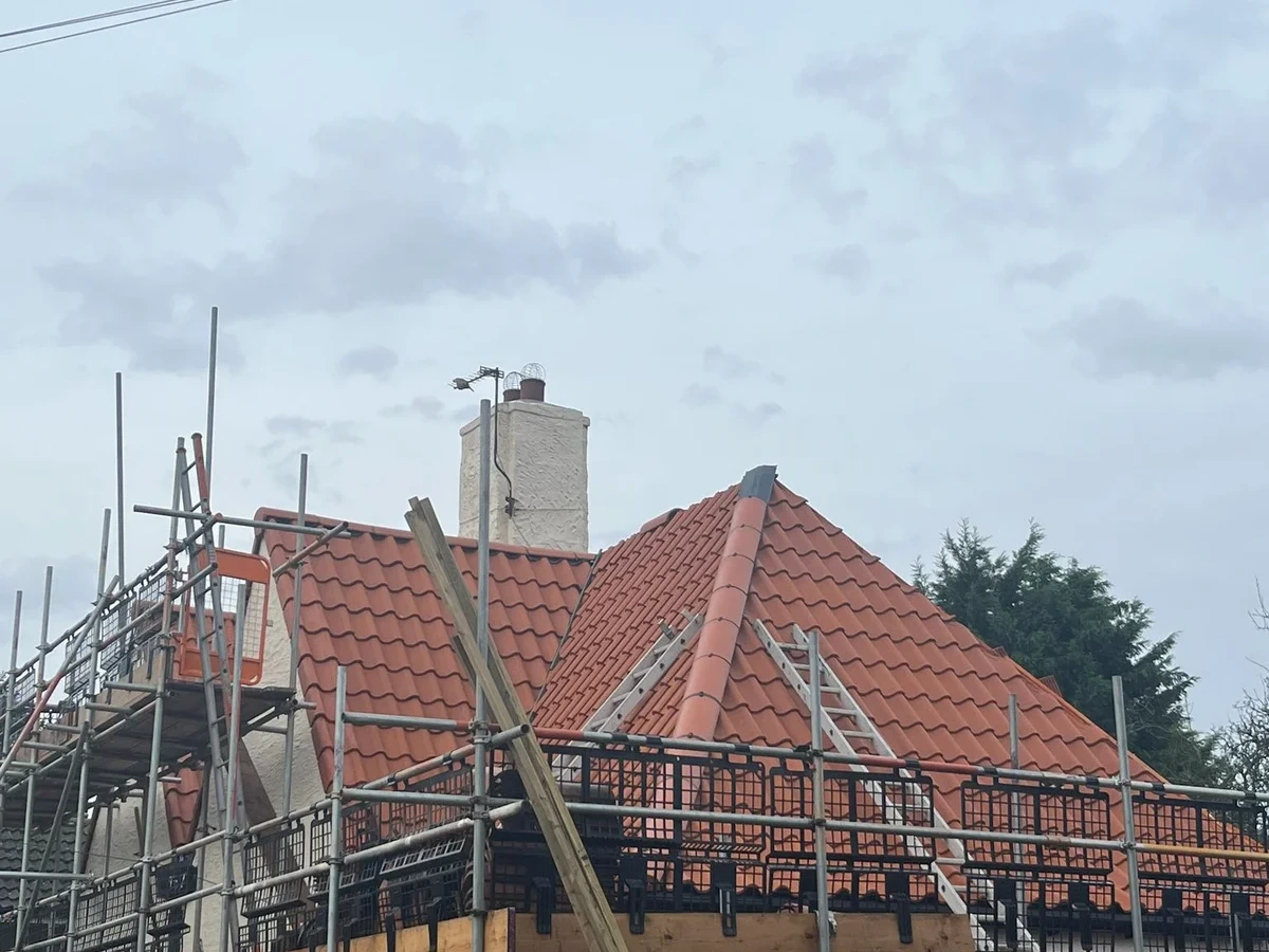 Roof renewal viewed from the side of the scaffolded house